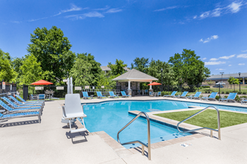A pool with a gazebo and sun loungers.